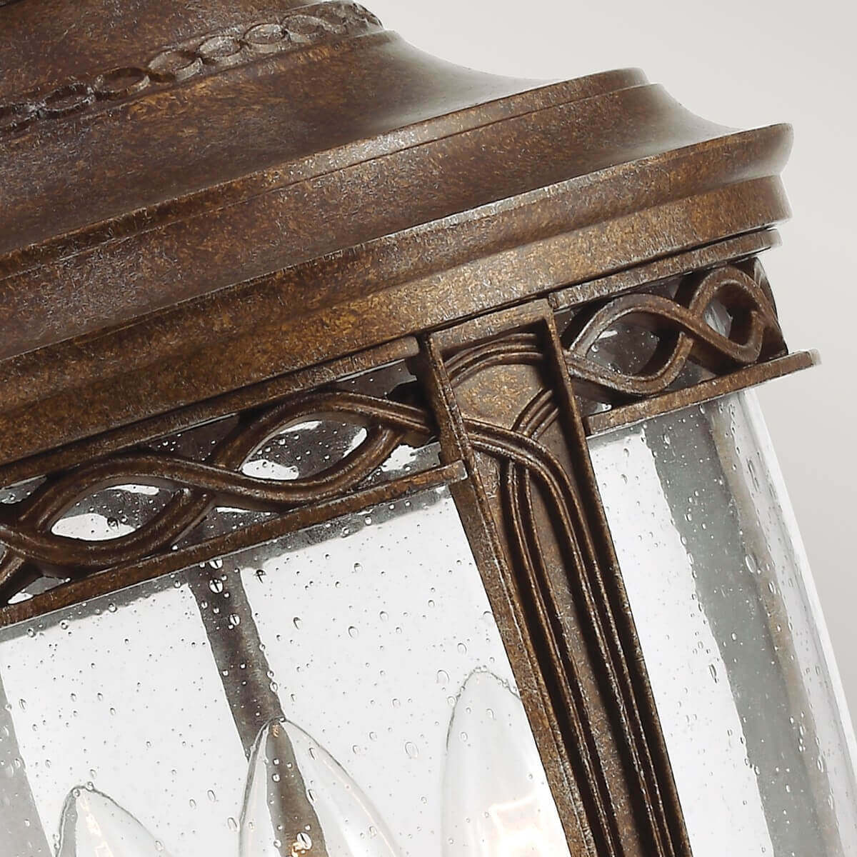 Détail de la ferronnerie ouvragée et du verre mouillé de la lanterne.