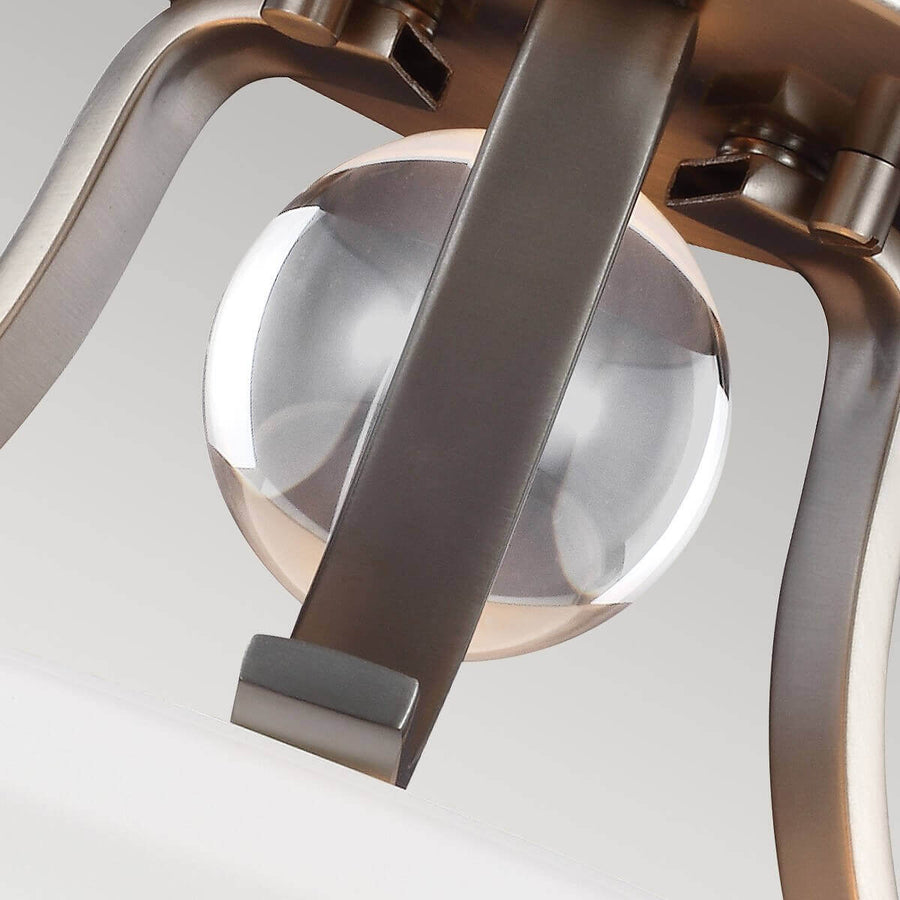 Détail rapproché de la sphère de verre central traversée par la platine métallique