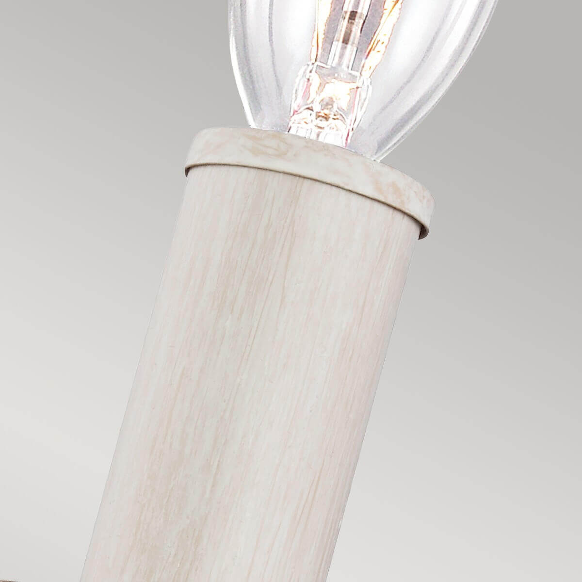 Gros plan sur la douille cylindrique blanche et l'ampoule transparente allumée