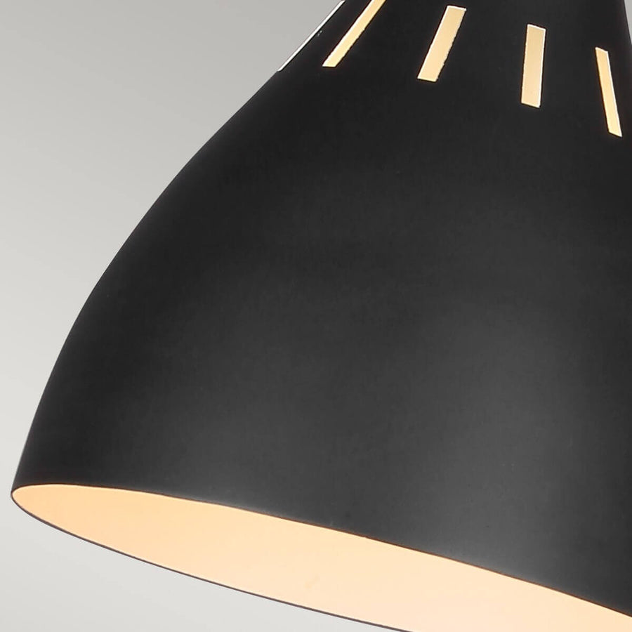 Détail de l'abat-jour noir ajouré avec lumière chaude qui filtre
