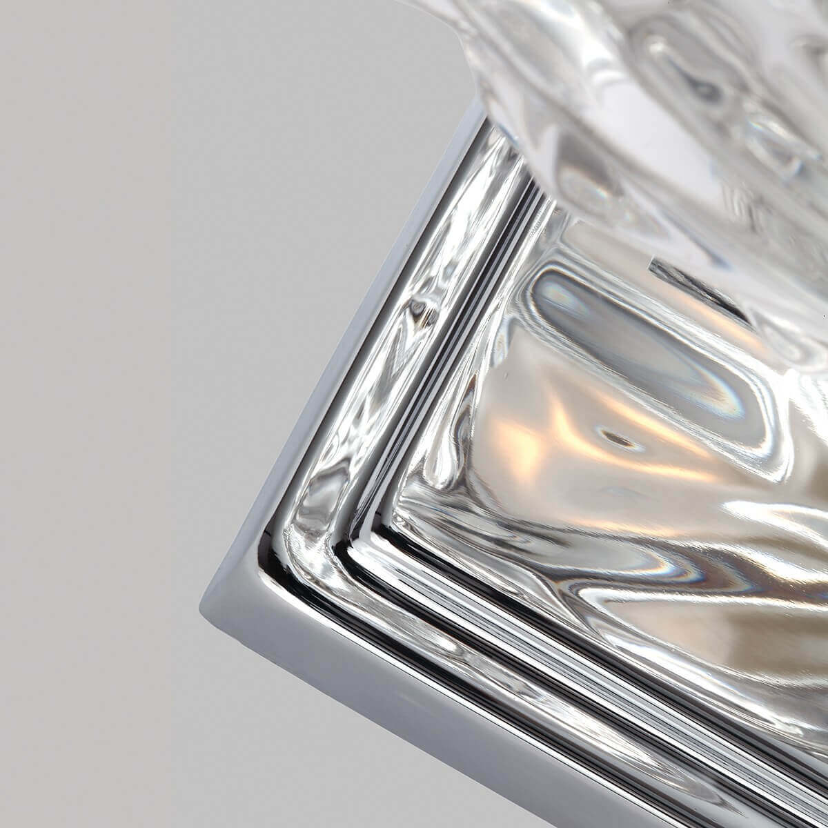 Détail du coin de la platine carrée en métal chromé poli et brillant