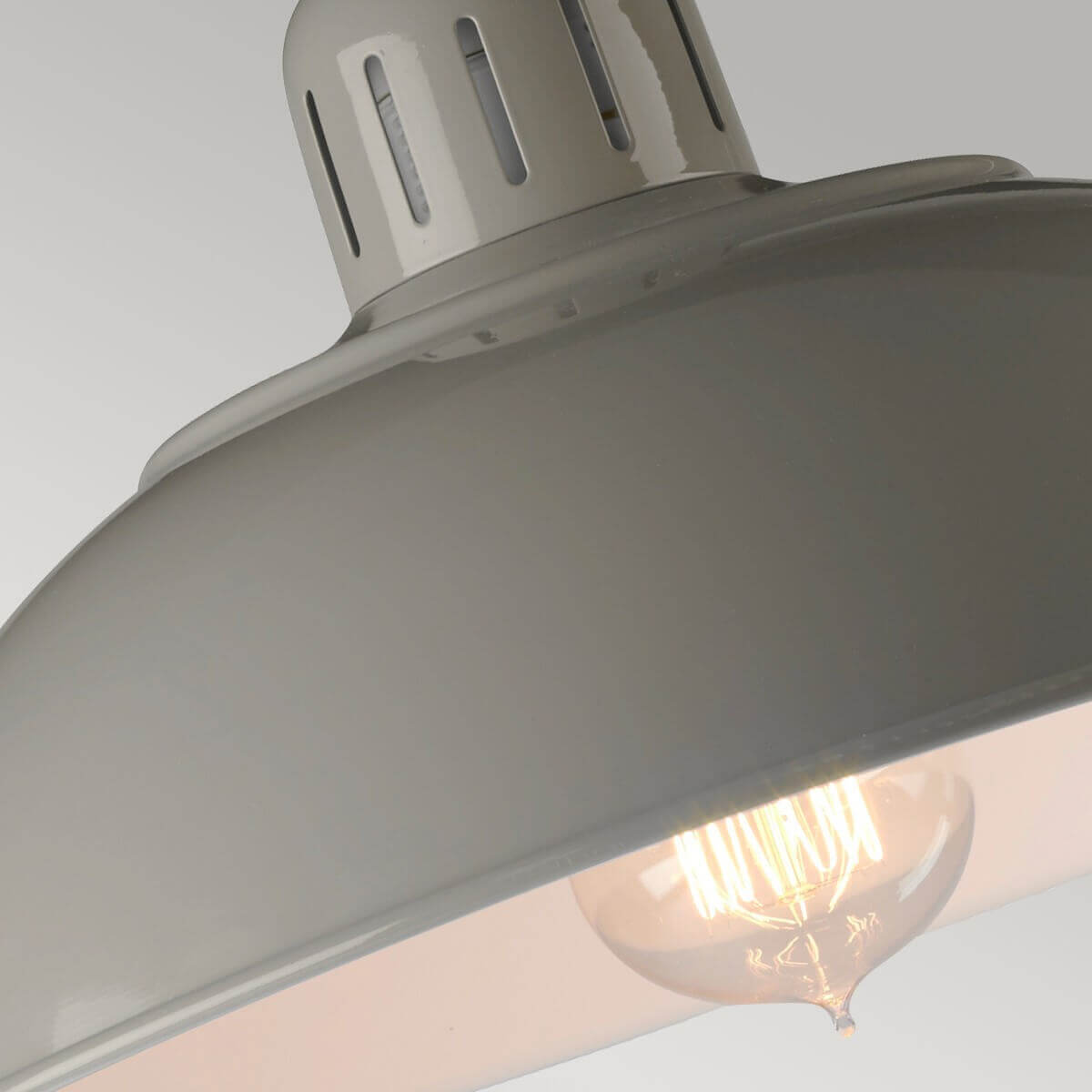 Vue rapprochée sous l'abat-jour gris éclairé par une ampoule à filament