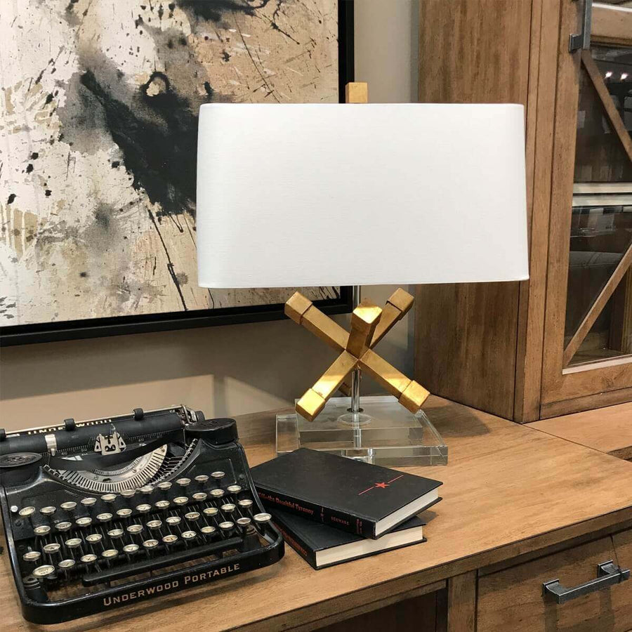 Scène de bureau en bois avec machine à écrire ancienne, livres et lampe dorée
