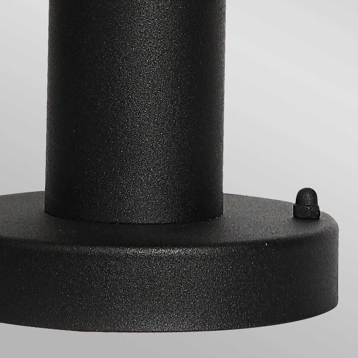 Détail de la base circulaire noire avec vis de fixation et finition grainée