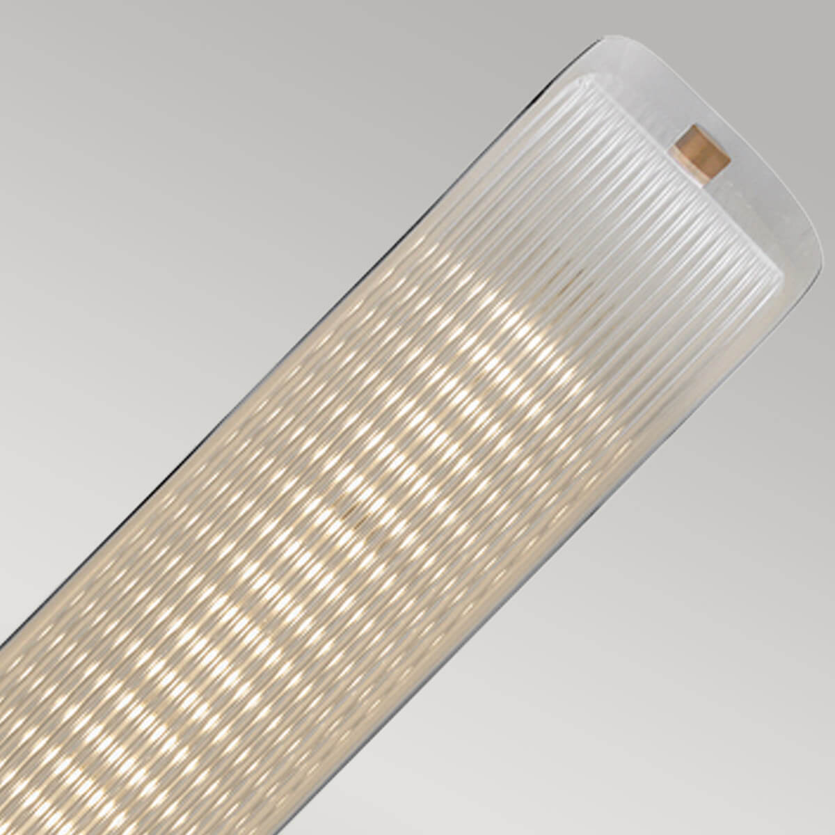 Gros plan du diffuseur en verre strié allumé, lumière chaude et diffuse