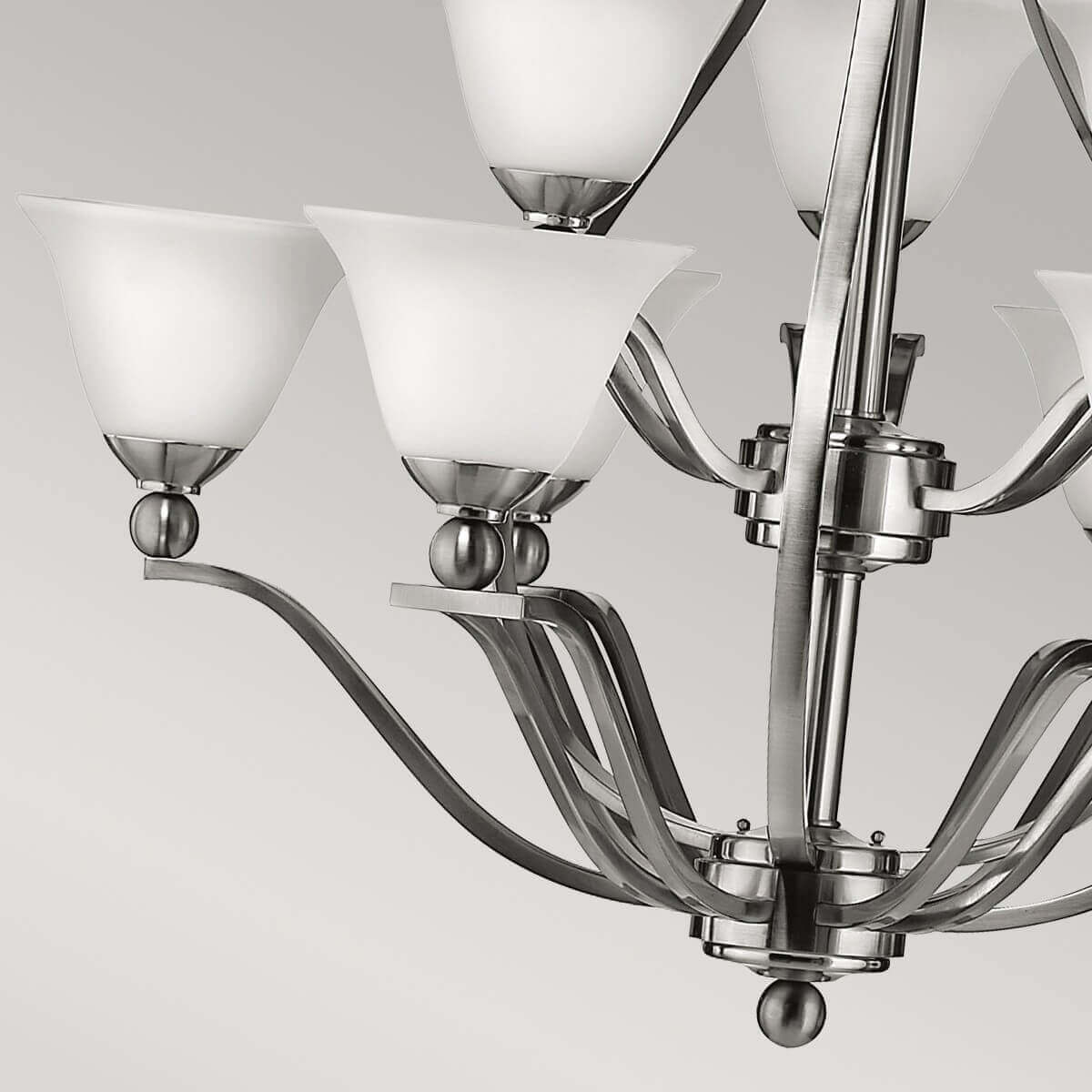 Vue rapprochée des bras courbes, sphères décoratives et embase inférieure du luminaire