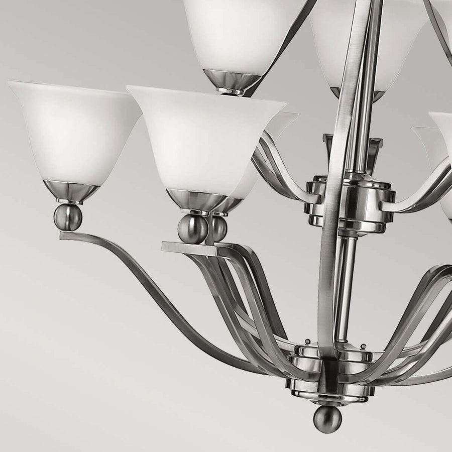 Vue rapprochée des bras courbes, sphères décoratives et embase inférieure du luminaire