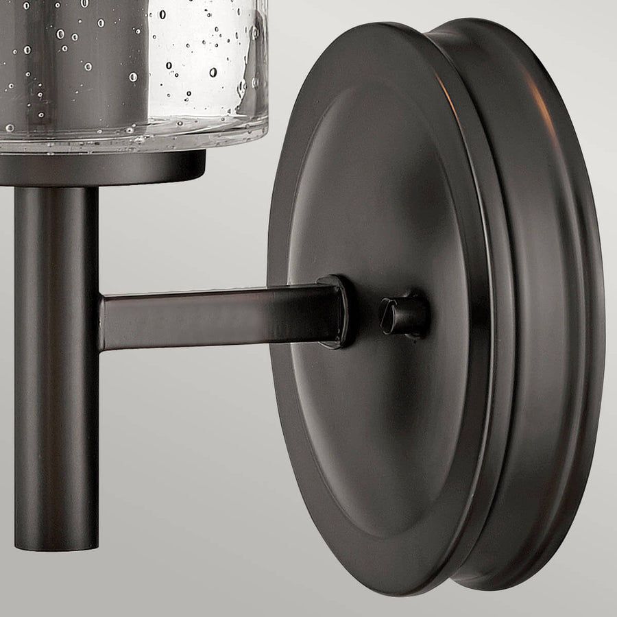 Vue rapprochée de la platine ronde noire et du bras de fixation au mur