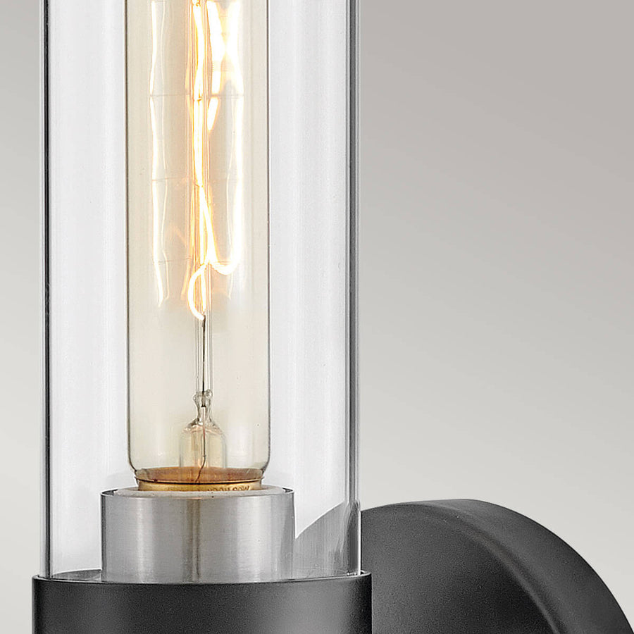 Détail de l'ampoule à filament dans le cylindre en verre transparent avec reflets.
