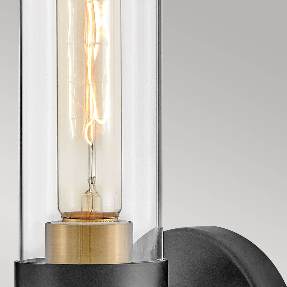 Gros plan sur le verre transparent et l'ampoule à filament allumée.