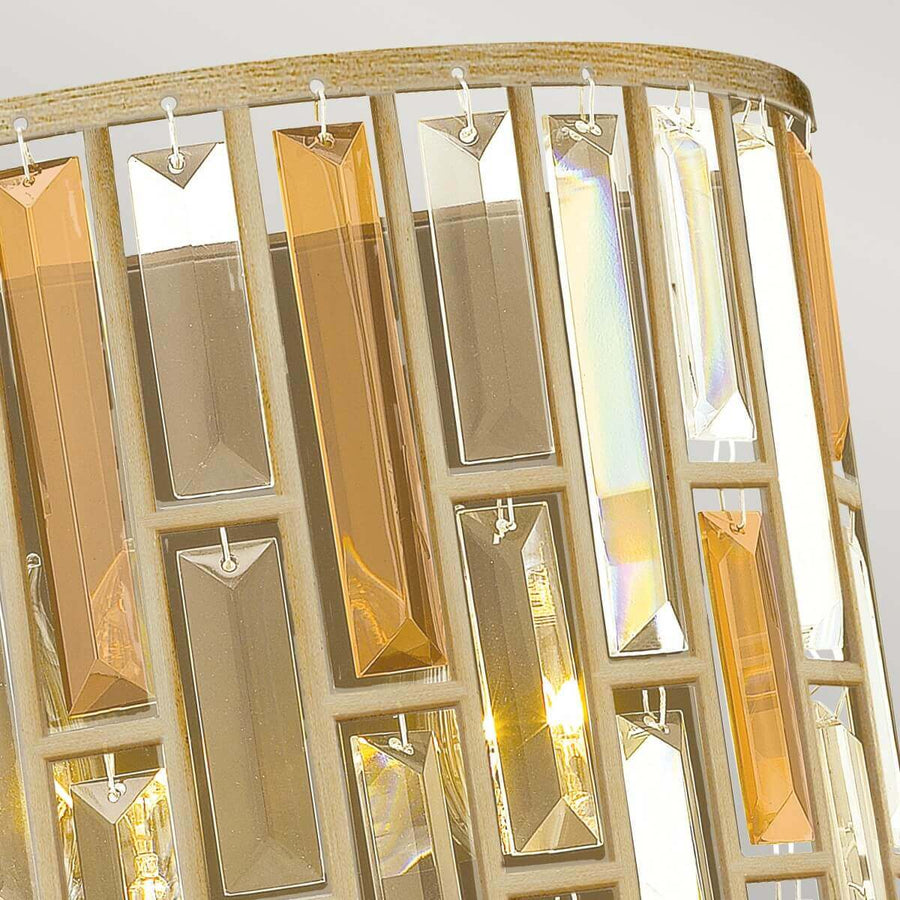 Détail du haut de l’applique, attaches métalliques et cristaux facettés suspendus.