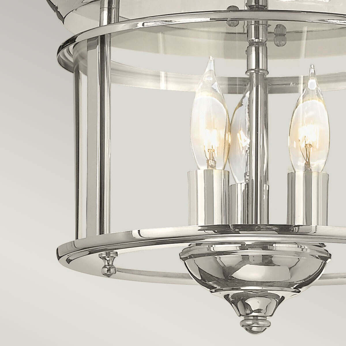 Détail du bas du luminaire montrant la coupole en nickel poli et sa fixation