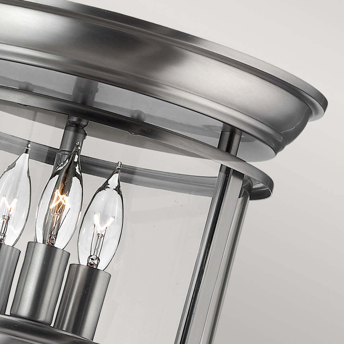 Détail du cercle métallique brossé et des douilles maintenant les ampoules.