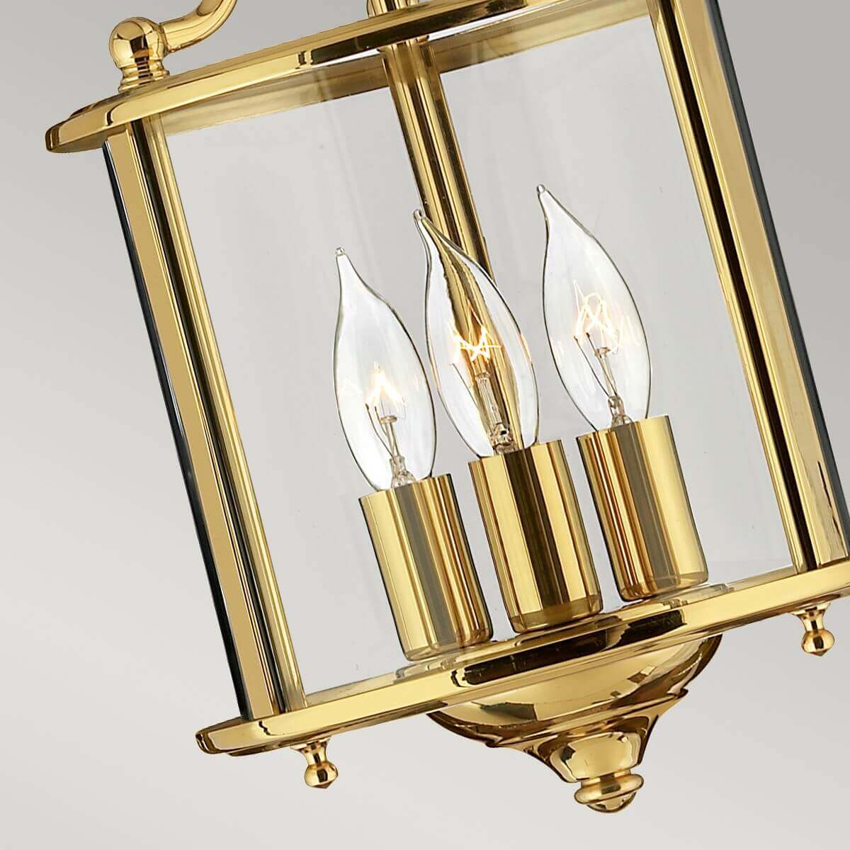 Détail du bas de la lanterne en laiton poli avec douilles cylindriques et ampoules flammes.