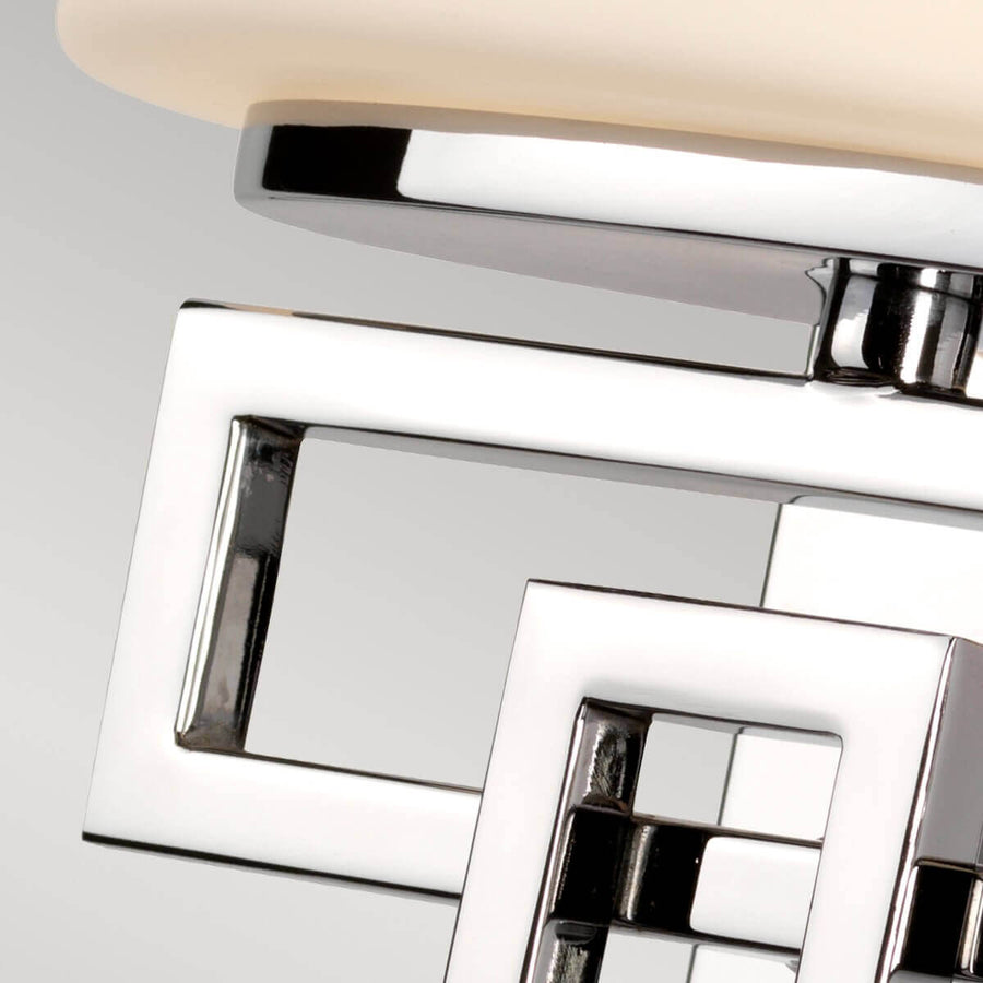 Détail du support chromé aux rectangles imbriqués reliant le verre à la platine