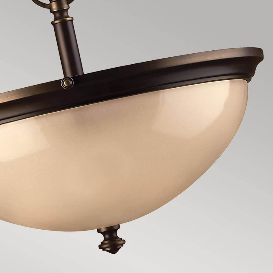 Détail du bol en verre ambré et de la finition inférieure en bronze ouvragé.