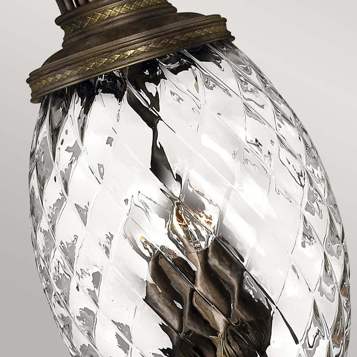 Gros plan du verre transparent facetté et de la bague supérieure cerclée bronze