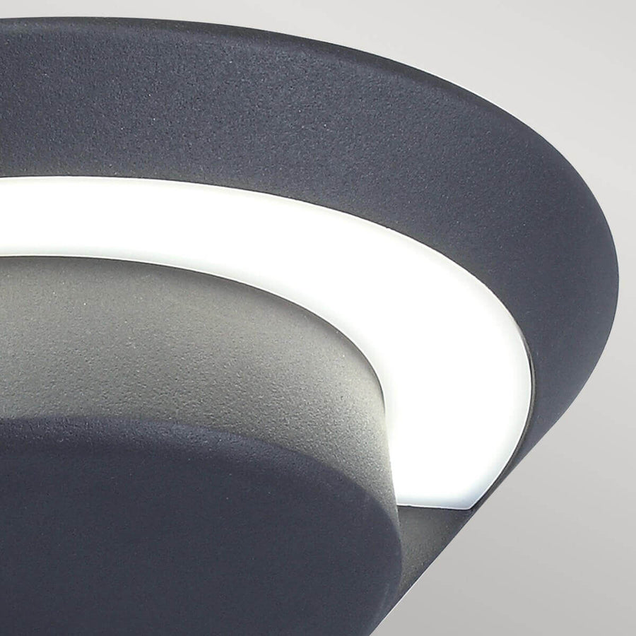 Gros plan sur le diffuseur blanc courbe et la texture granuleuse anthracite