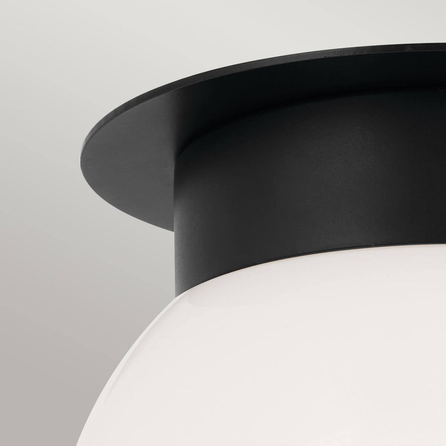 Détail de la base cylindrique noire et du sommet de la sphère en verre opalin.