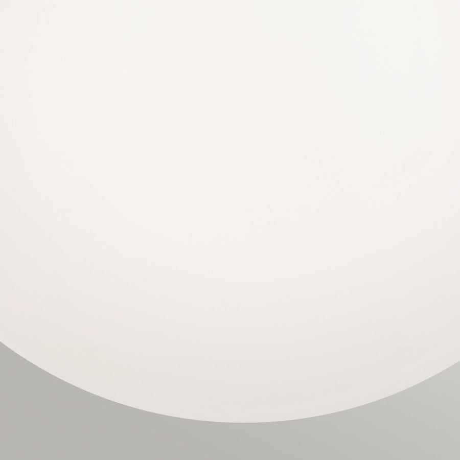 Gros plan sur la surface lisse et laiteuse du globe en verre opale dépoli.