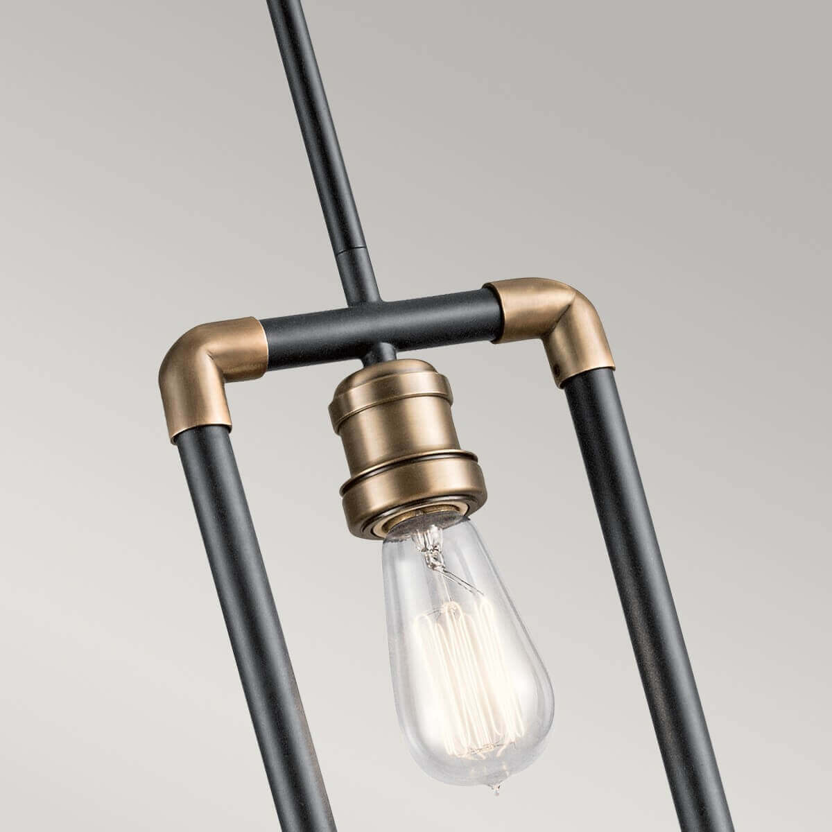 Gros plan sur le raccord central, la douille et l'ampoule Edison allumée.