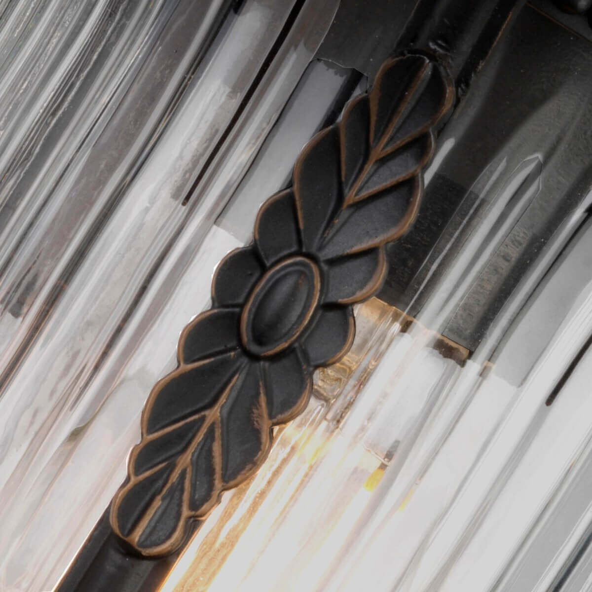 Détail de la rosace en feuille métallique sur verre strié éclairé