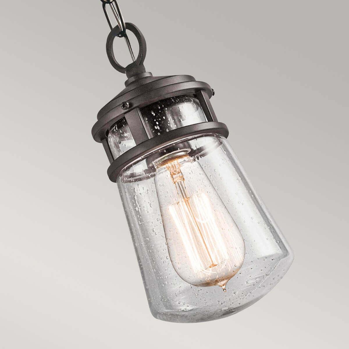 Gros plan incliné du verre moucheté et de l'ampoule à filament allumée.
