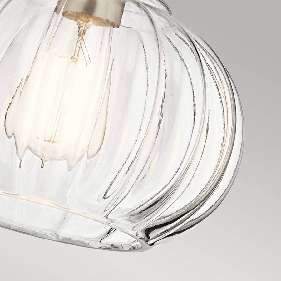Vue rapprochée du verre godronné transparent laissant voir l'ampoule allumée à l'intérieur