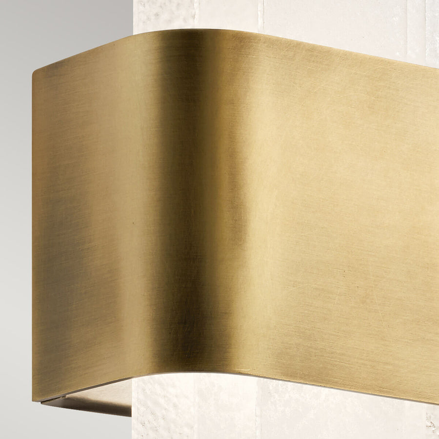 Gros plan sur la courbure du bandeau en laiton brossé doré