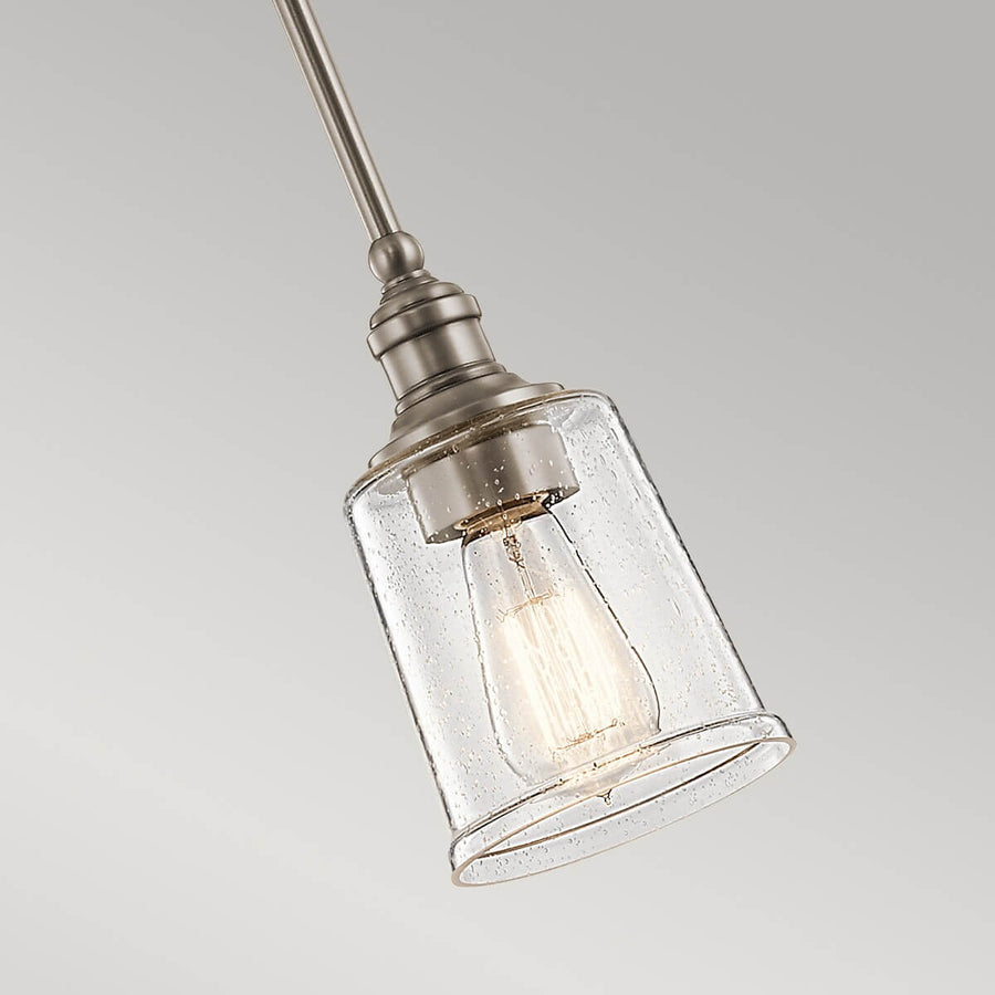 Gros plan sur l'abat-jour en verre grésé et l'ampoule Edison allumée
