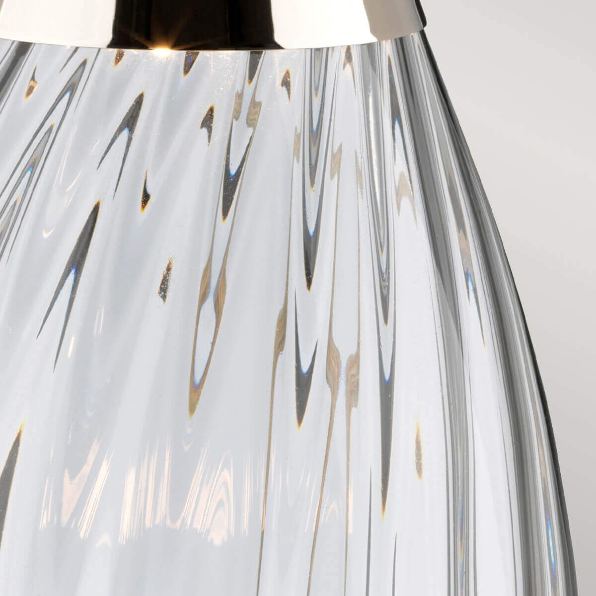 Gros plan sur le verre strié et ses reflets dorés sous la lumière