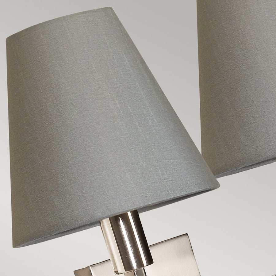 Zoom sur un abat-jour en tissu gris et sa douille cylindrique nickelée