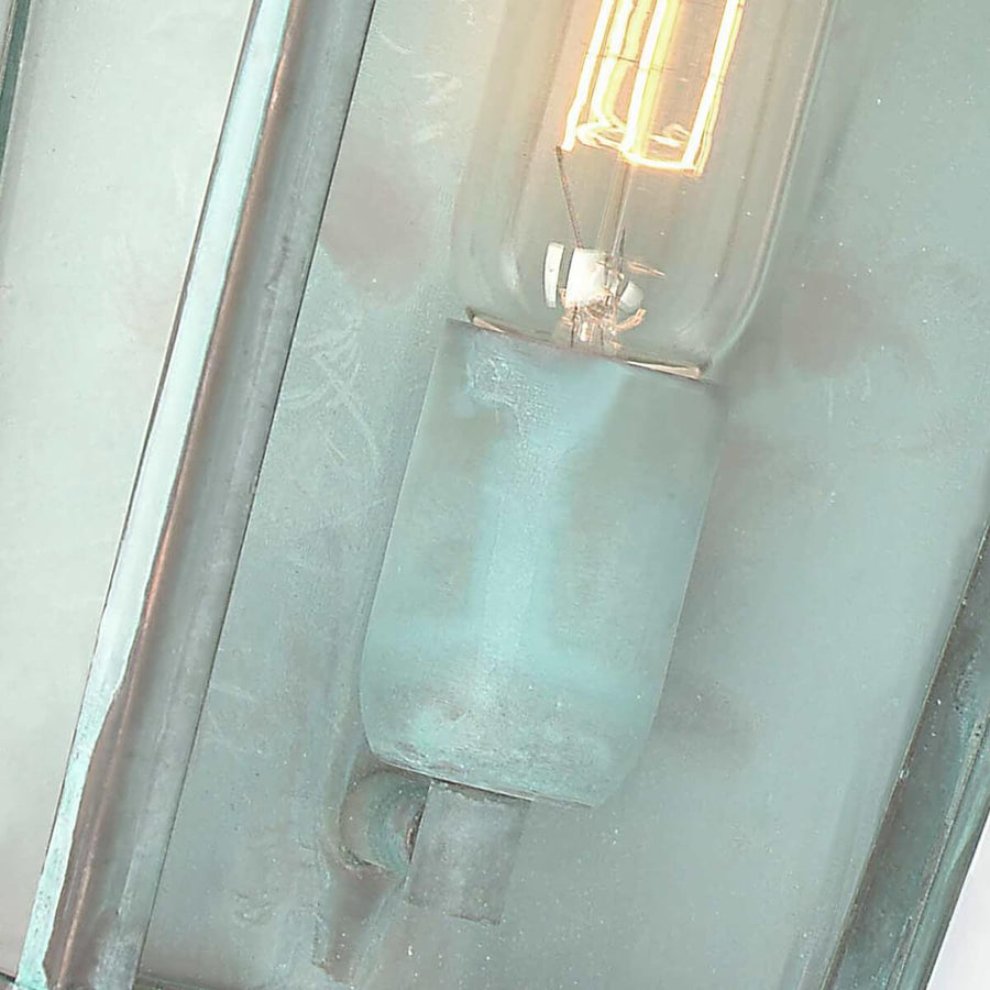 Gros plan sur la douille et l'ampoule allumée derrière la vitre du luminaire