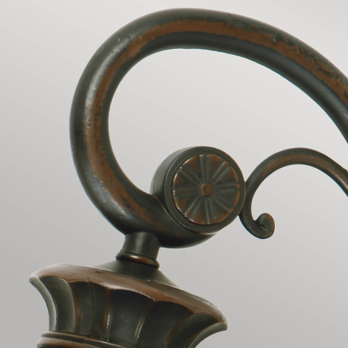 Détail du support cintré et du cabochon floral en bronze patiné