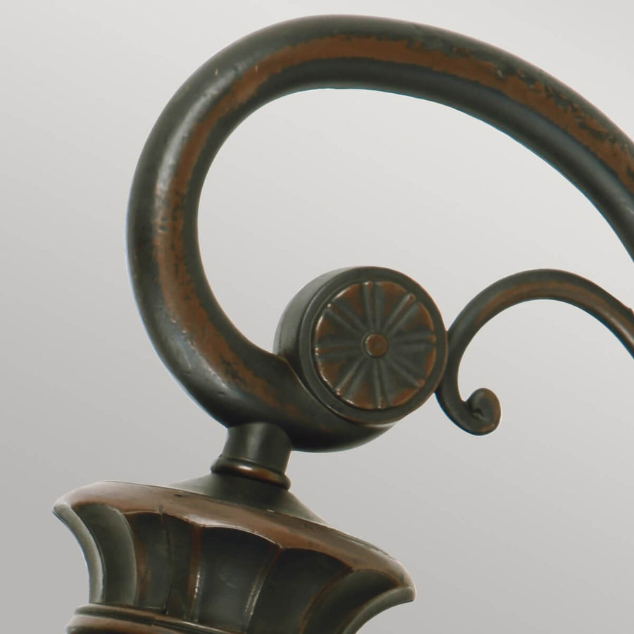 Détail du support cintré et du cabochon floral en bronze patiné