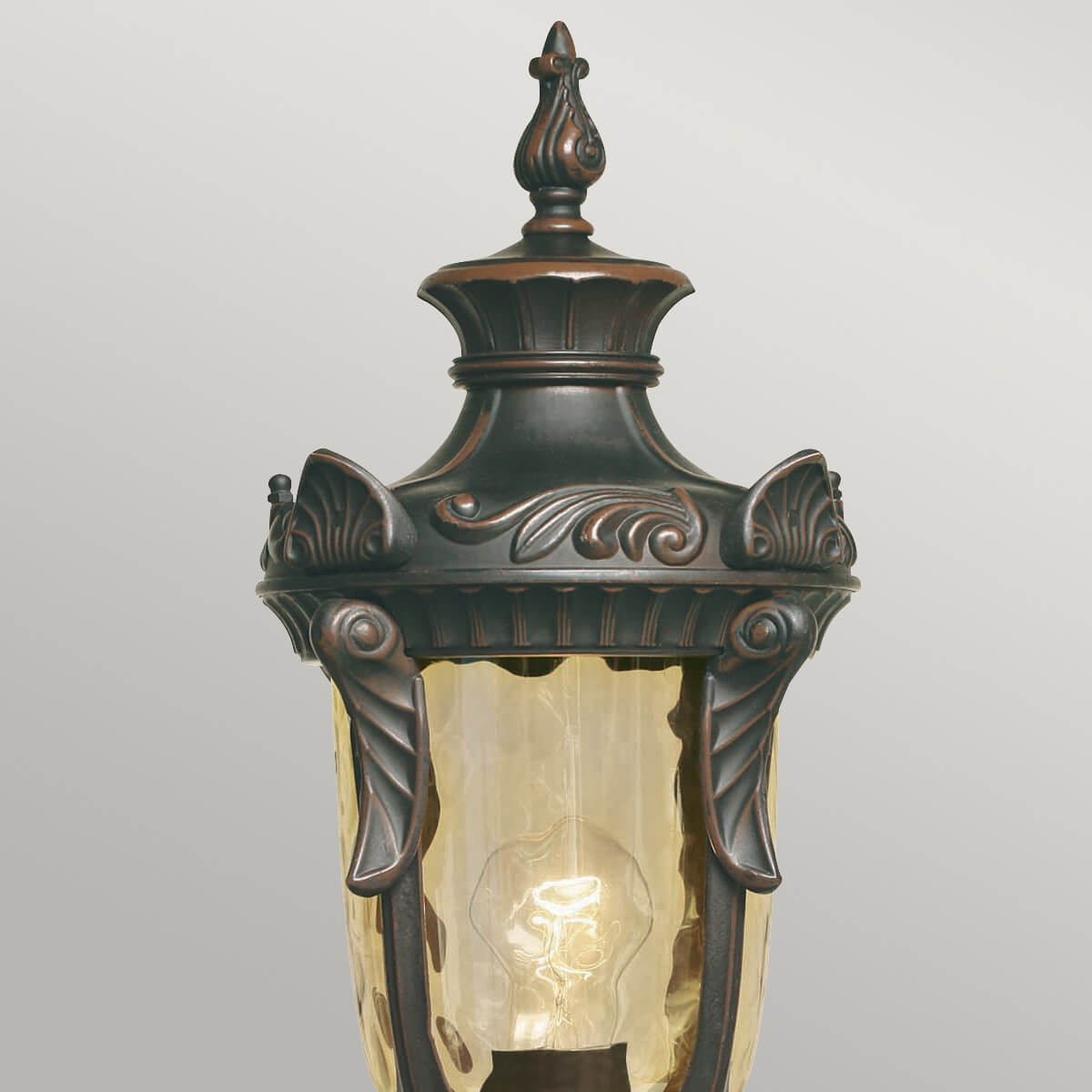 Détail du chapiteau ornementé et du verre ambré texturé de la lanterne