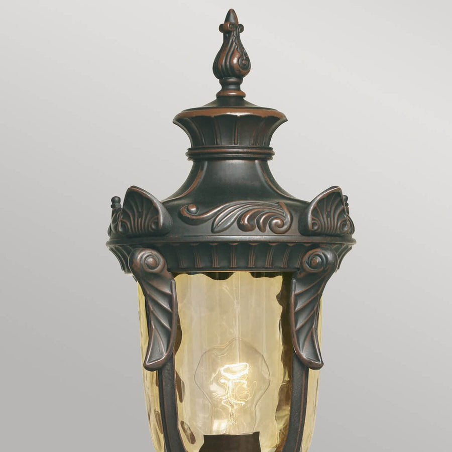 Détail du chapiteau ornementé et du verre ambré texturé de la lanterne