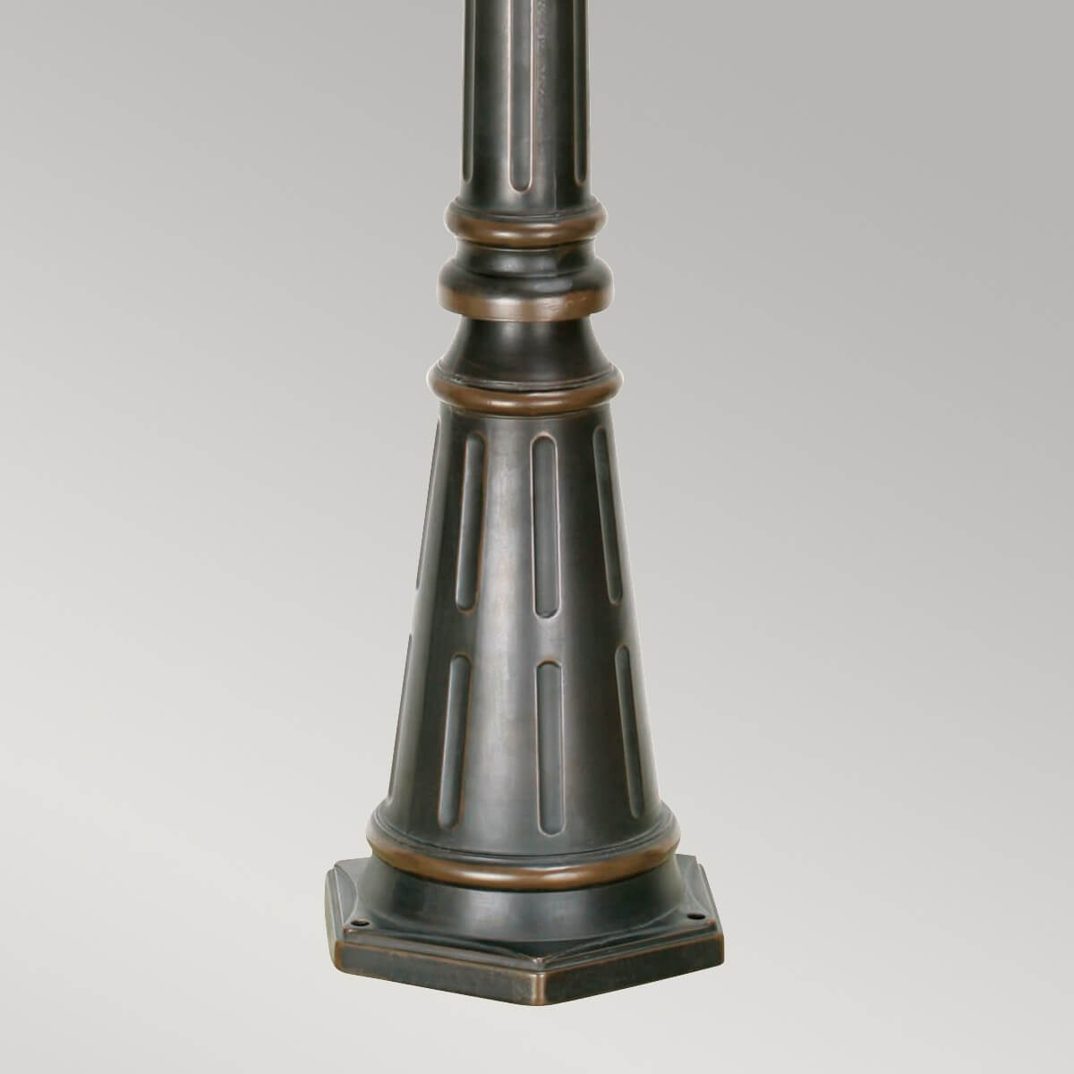 Détail de la base trapézoïdale cannelée avec socle carré et trous de fixation