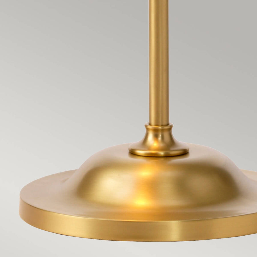 Détail de la base ronde et du pied cylindrique en laiton brossé.