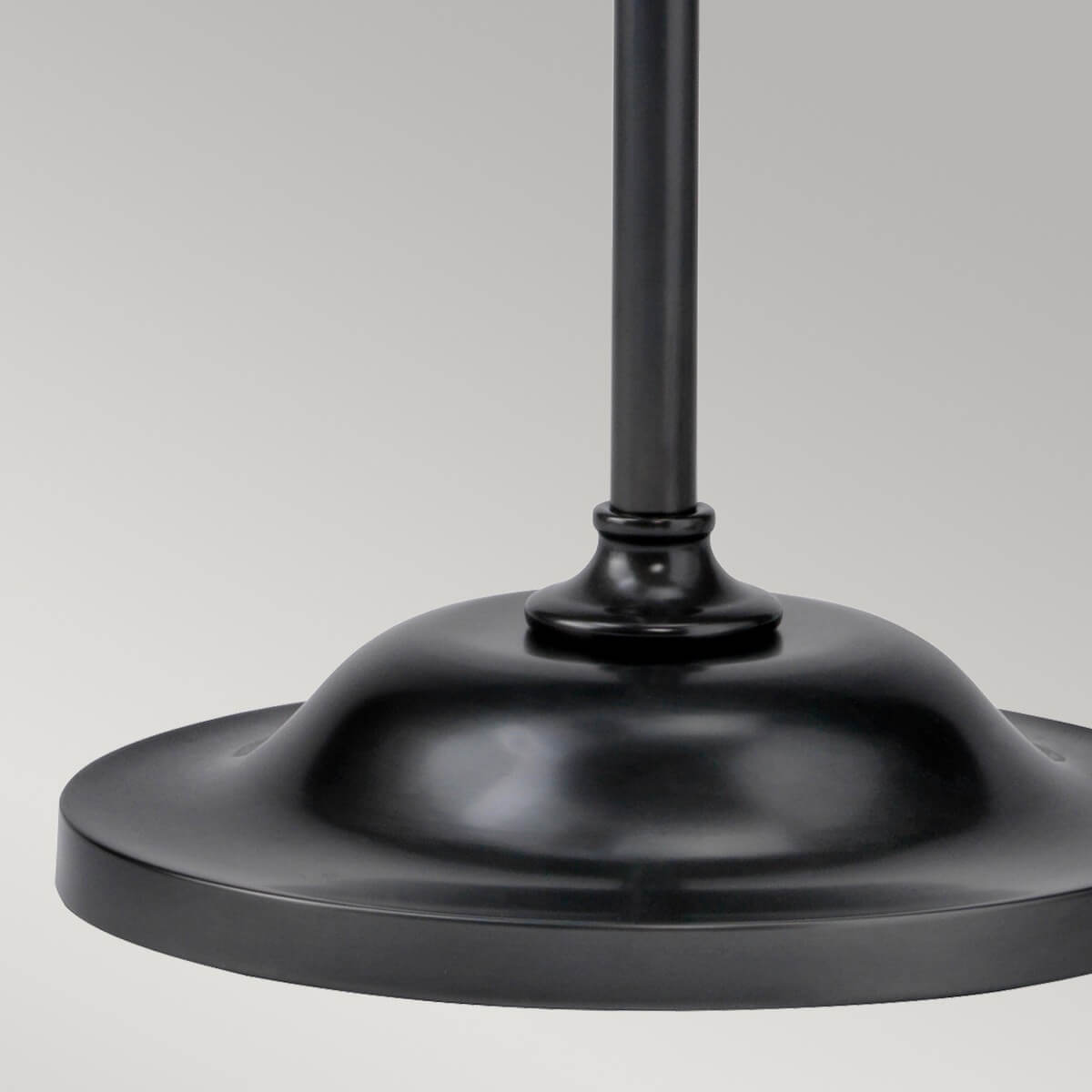 Détail de la base ronde et bombée du pied, finition métal noir satiné.
