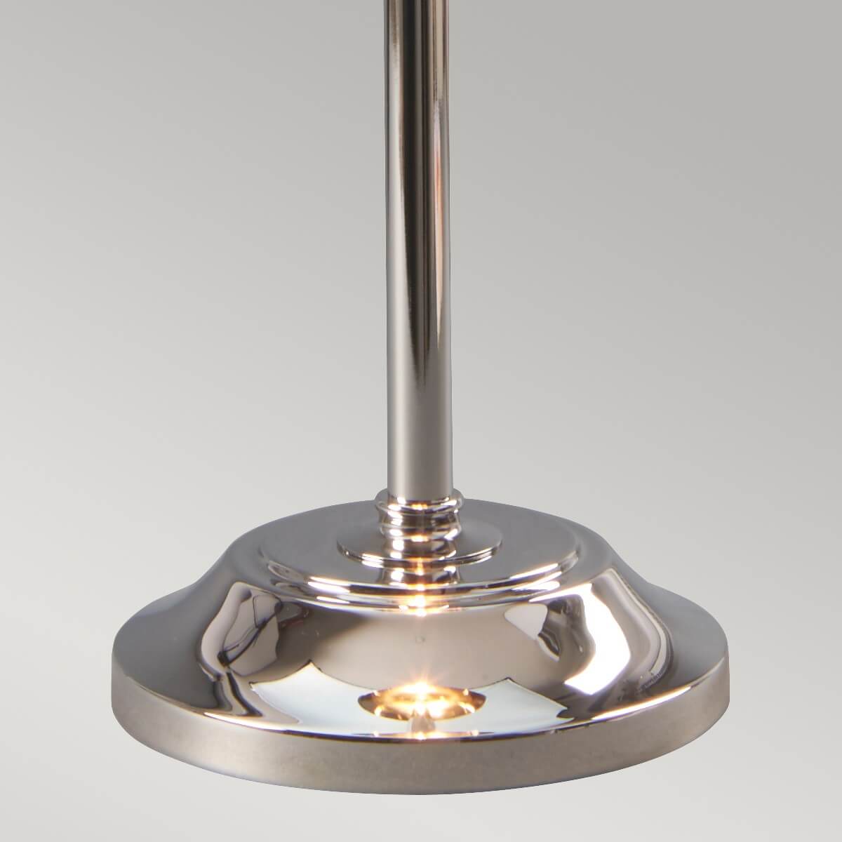Détail de la base ronde et du pied cylindrique en nickel poli.