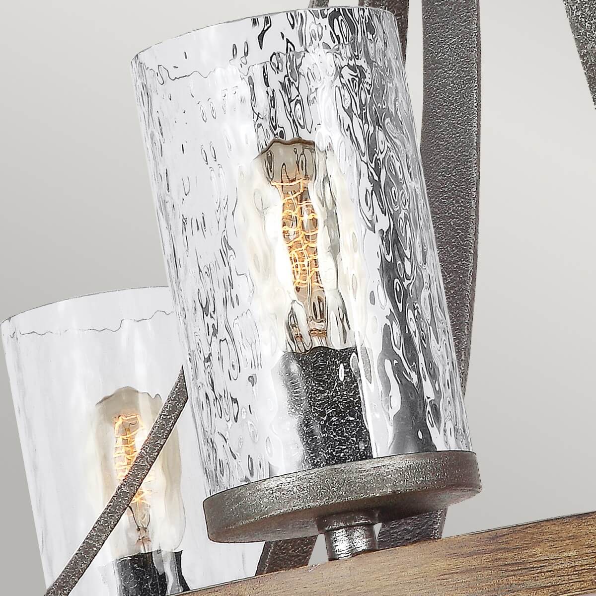 Gros plan d'un abat-jour cylindrique en verre martelé et son ampoule dorée
