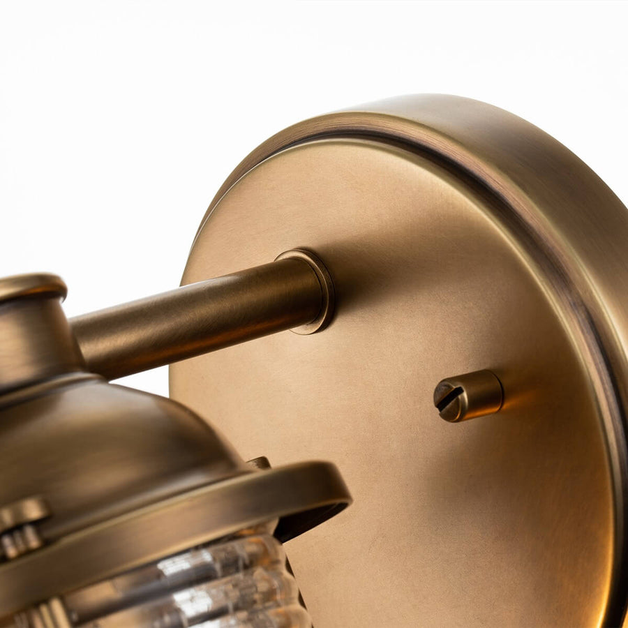 Détail de la platine ronde en métal brossé et de son support fixé au mur