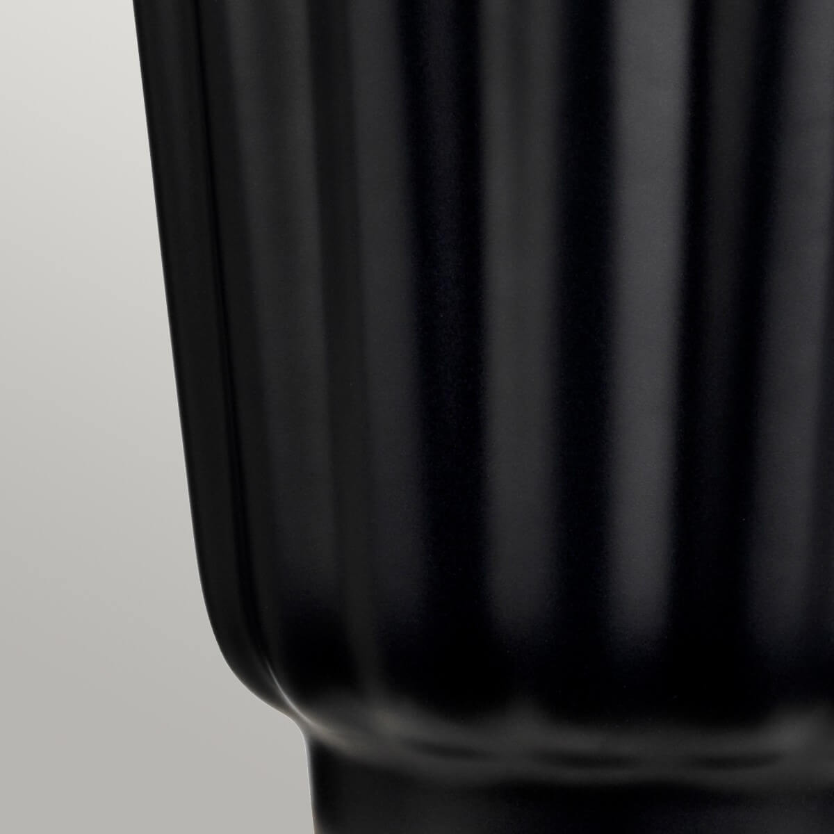 Détail de la base céramique noire brillante aux côtes verticales régulières
