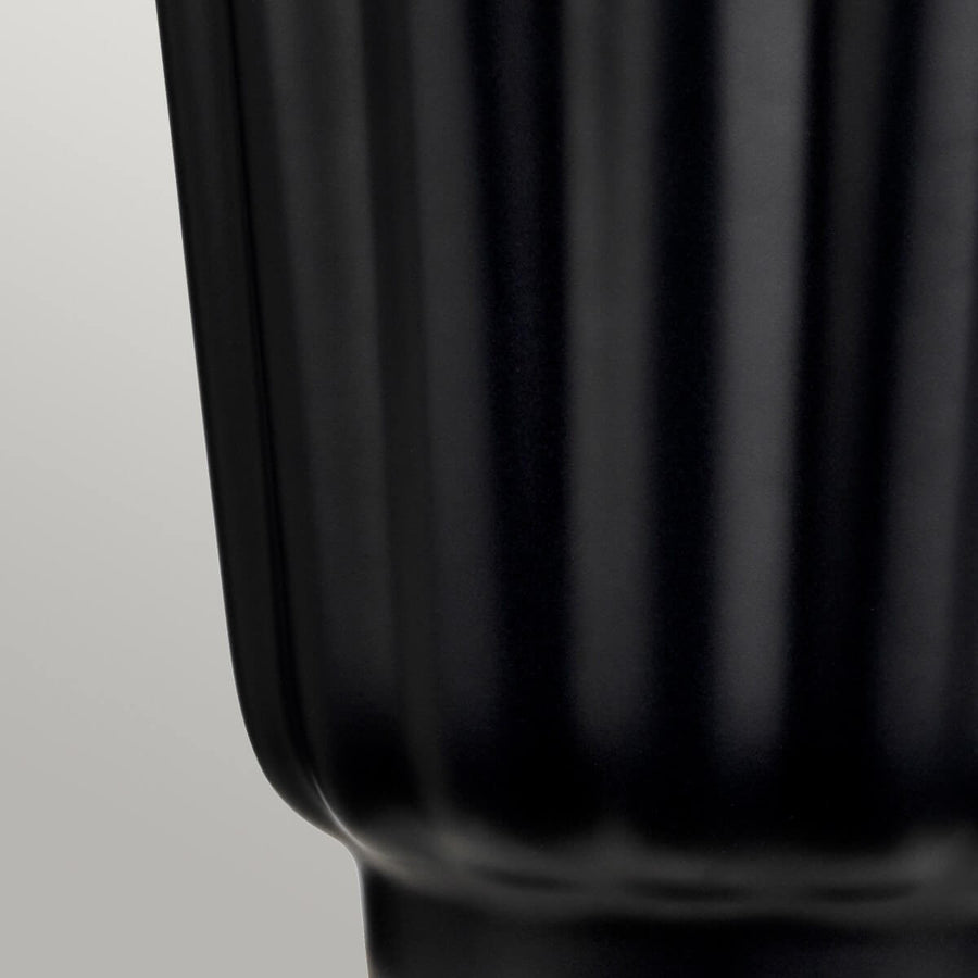 Détail de la base céramique noire brillante aux côtes verticales régulières