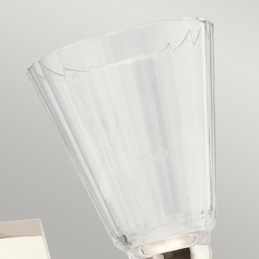 Gros plan sur la coupelle en verre transparent à côtes et bord supérieur festonné.