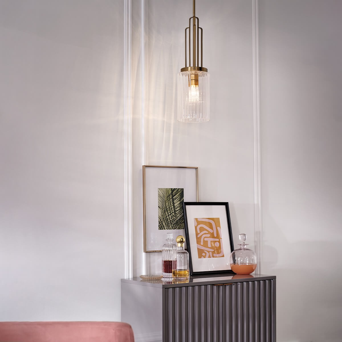 Mise en ambiance dans un intérieur clair avec cadre photo et flacons décoratifs sur meuble
