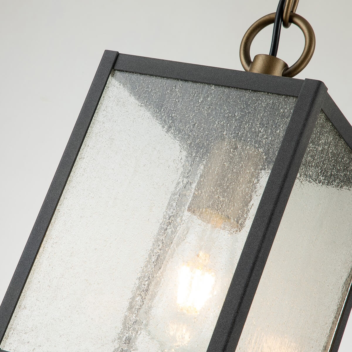 Gros plan sur le verre texturé et l'ampoule allumée à l'intérieur.