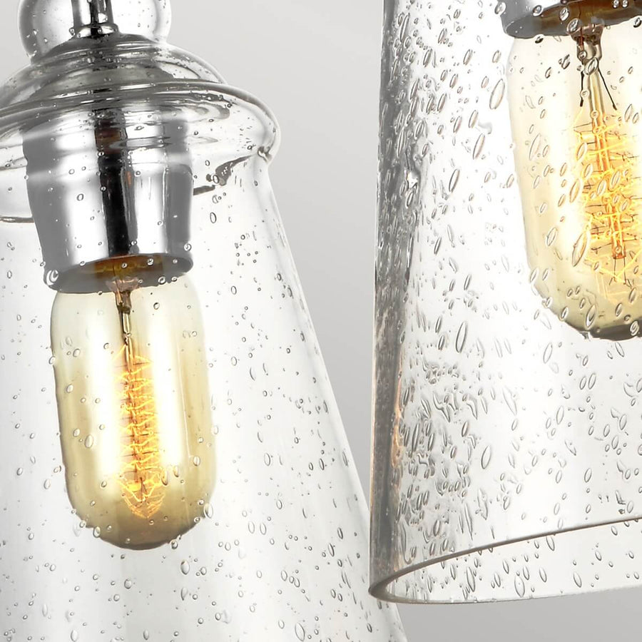 Détail des ampoules allumées sous les cloches en verre clair moucheté de bulles