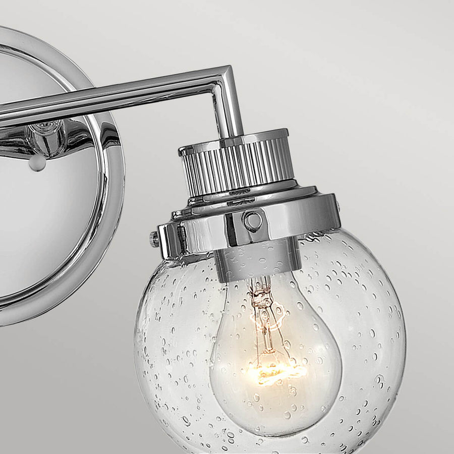 Détail du raccord métallique moleté et du globe en verre bullé laissant voir l'ampoule